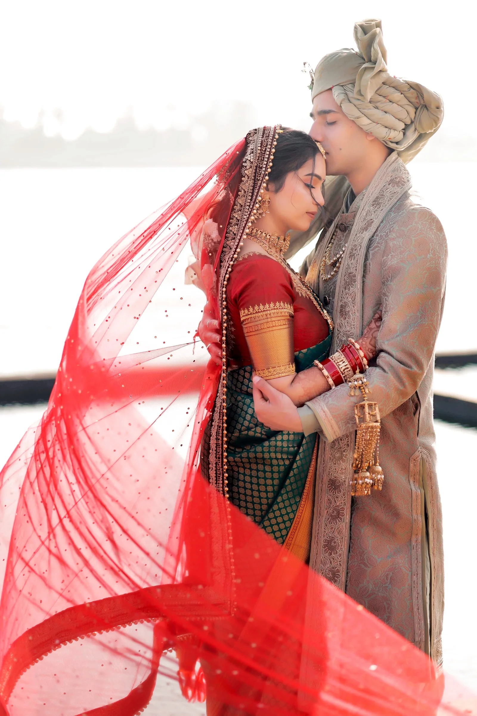 Groom kissing the bride on her forehead