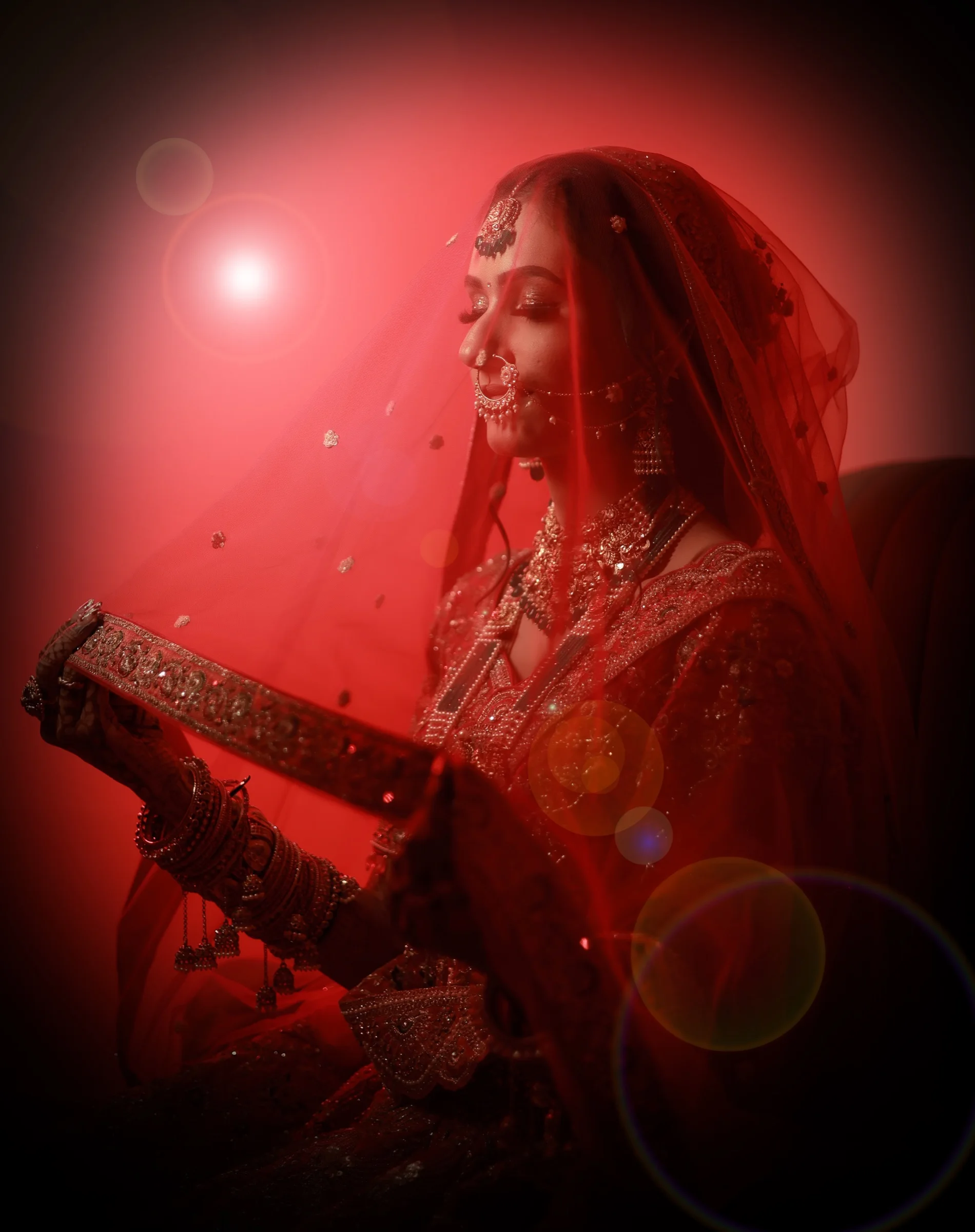 Bride glowing beneath a red veil